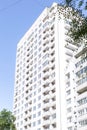 Building construction and architecture. The facade of a new high-rise bright house with balconies and windows against a blue sky Royalty Free Stock Photo