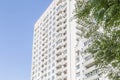 Building construction and architecture. The facade of a new high-rise bright house with balconies and windows against the blue sky Royalty Free Stock Photo