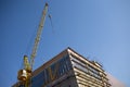 Building with construction crane and scaffolding blue sky