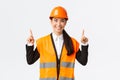 Building, construction and industrial concept. Satisfied successful female asian saleswoman showing clients object for