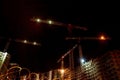 Building construction site with cranes and light flare at night time background Royalty Free Stock Photo