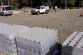 Building construction site with stacks of cinder concrete blocks.