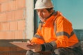 Building contractor and construction engineer making sketches and writing notes on building site Royalty Free Stock Photo