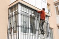 Building contractor installing balcony window iron security bars. Metal grid for windows and balcony.