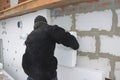 A building contractor is installing an external solid wall insulation fixing insulating polystyrene panels to the wall with Royalty Free Stock Photo