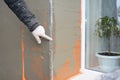 Building contractor plastering wall, stucco after rigid insulation in window sill problem area.