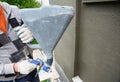 A building contractor is renovating, rendering exterior walls of the house, applying stucco, spaying texture using a texture air Royalty Free Stock Photo