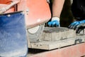 Building contractor using an angle grinder to cut a paving stone