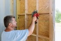 Building contractor worker using hand electric circular saw to cut wooden plank boards Royalty Free Stock Photo