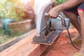 Building contractor worker using hand held worm drive circular saw to cut boards on a new home constructiion project Royalty Free Stock Photo