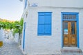 Building on corrner two lanes, whitwashed with blue door and shutter