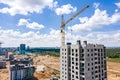 Building crane and buildings under construction against blue cloudy sky. aerial view Royalty Free Stock Photo
