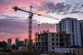 Building crane and buildings under construction against evening sky Royalty Free Stock Photo