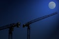 Building cranes at night