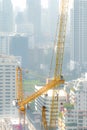 Building crew dissemble tower crane on a hazy day.