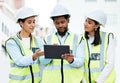 Building, digital tablet and construction worker team collaboration and planning at a site, checking online plan and Royalty Free Stock Photo