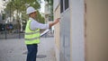 Building expert conducting inventories writing paper outdoors. Electrician man