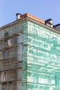 Building under renovation with scaffolding and green netting Royalty Free Stock Photo