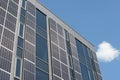 Building facade embellished with solar panels. Solar panels gracing a modern building\'s wall Royalty Free Stock Photo