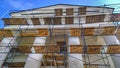 Building facade renovation. Construction site with scaffolding. Restoration of ancient house. Columns repairing. Reconstruction. R