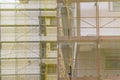 Building facade renovation, old house reconstruction, repair. Scaffold in front of building facade covered with yellow transparent Royalty Free Stock Photo