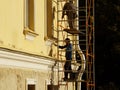 Building facade repair by construction workers from scaffolding