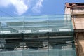 Building facade under renovation works with construction scaffolding frame covered with protective net for workers Royalty Free Stock Photo