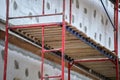 Building facade under renovation works with construction scaffolding frame. Wall insulation with styrofoam sheets for Royalty Free Stock Photo