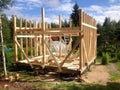 Building the frame of a wooden house. Stage of the erection of the wall frame. The House on stilts. Summer, suburban constructio Royalty Free Stock Photo