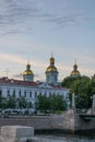 The building and the golden domes of the Orthodox Church at dusk, the river. Cloudy sky. Evening in St. Petersburg.