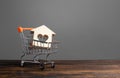 Building with a heart in a shopping cart. The concept of buying a house or apartment. Affordable housing. Profitable and cheap Royalty Free Stock Photo