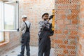 Building house construction workers installing window and checking wall Royalty Free Stock Photo