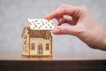 Building a house, a woman attaches a roof to the house