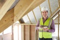 Building Inspector Looking At Roof Of New Property