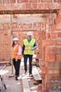 Building inspectors in hardhats and hi vis vests walking along construction site Royalty Free Stock Photo