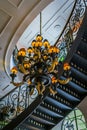 Architecture interior, candelabra and curved staircase viewed from below.