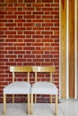 Building interior with wooden chairs and red brick wall. Royalty Free Stock Photo