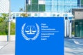 building of International Criminal Court with (ICC) in Hague, logo, text on blue flag background, poster banner