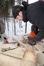 Building the log walls, cutting round saddle notch using chainsa