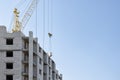 Building of a multi-storey brick house with help of construction crane. Royalty Free Stock Photo