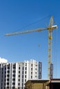 Building a new multi-storey house made of bricks with the help of a building crane.