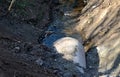 When building a new road, it is necessary to bridge the stream with the help of a metal pipe only for the duration of the construc Royalty Free Stock Photo