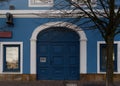 building with old blue gate and white framed window in old town Royalty Free Stock Photo