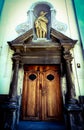 Building with an old door and statue above.