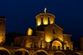 The building of an old stone monastery that looks like a castle. At night, the building is illuminated in bright yellowish colors Royalty Free Stock Photo