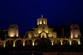 The building of an old stone monastery that looks like a castle. At night, the building is illuminated in bright yellowish colors Royalty Free Stock Photo