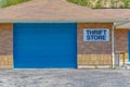 Building with pitched roof and large blue door viewed on a sunny day Royalty Free Stock Photo