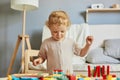 Building a playful preschooler. Learning through play. Focused wavy haired blonde infant baby playin