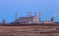 Building of a power plant with smoking pipes and glowing lights