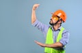 Building process control. Worker builder with helmet gesticulates with hands and supervises the building